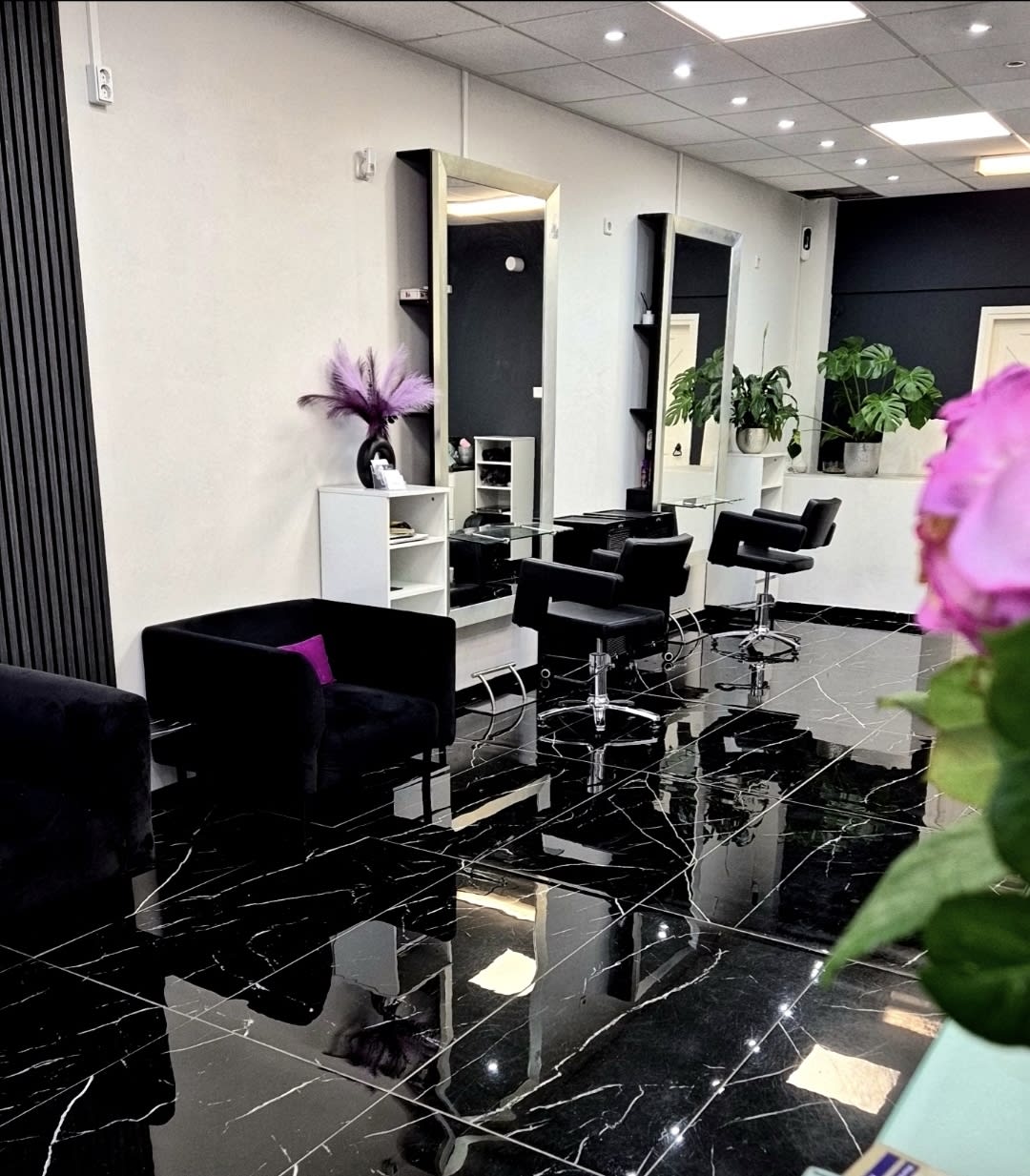 Binnen in de salon: marmeren vloer, spiegels, planten en lila veren